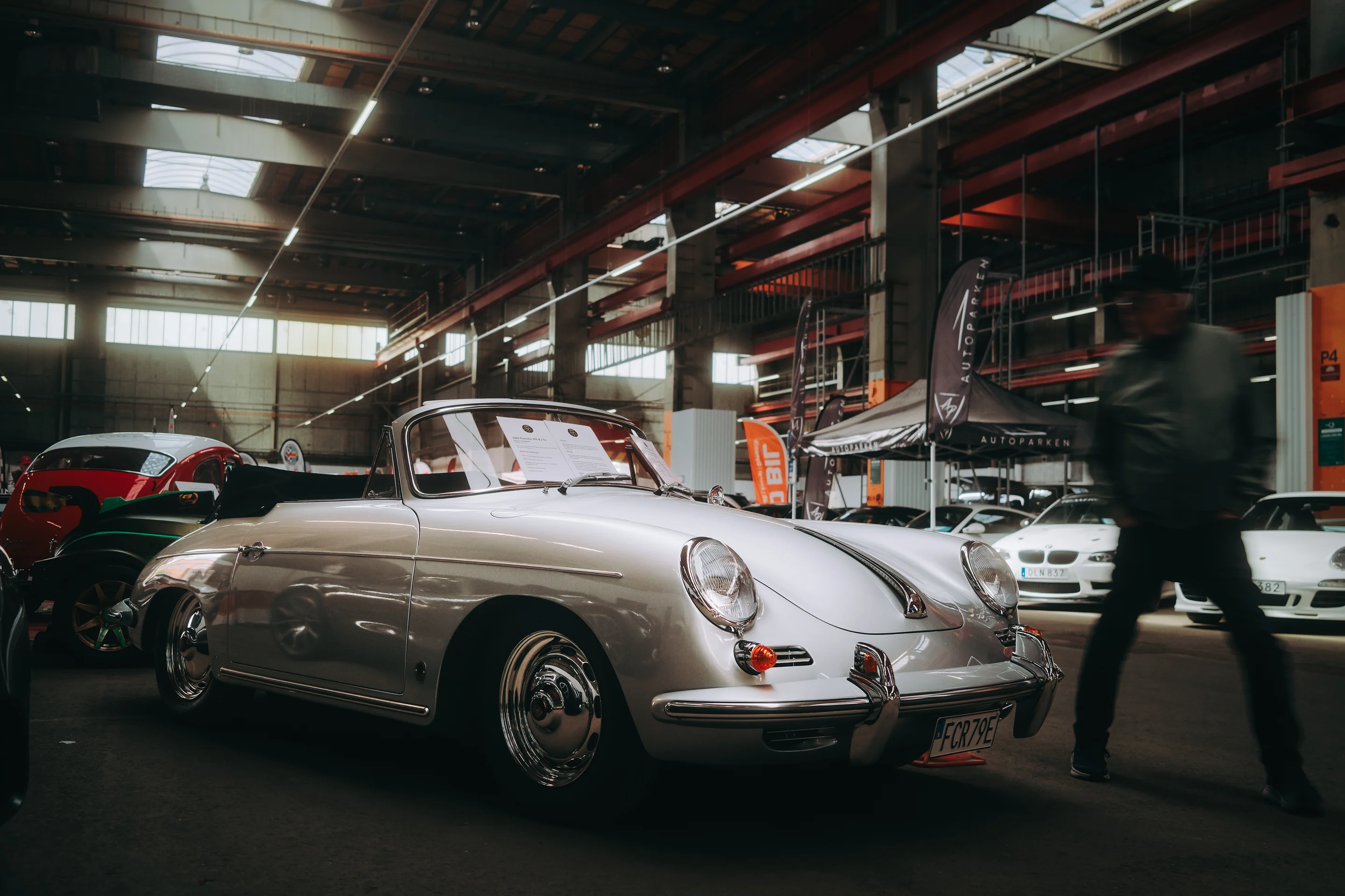 Silverfärgad klassisk cabriolet i en industrihall full av bilar på Gothenburg Classic Car Weekend