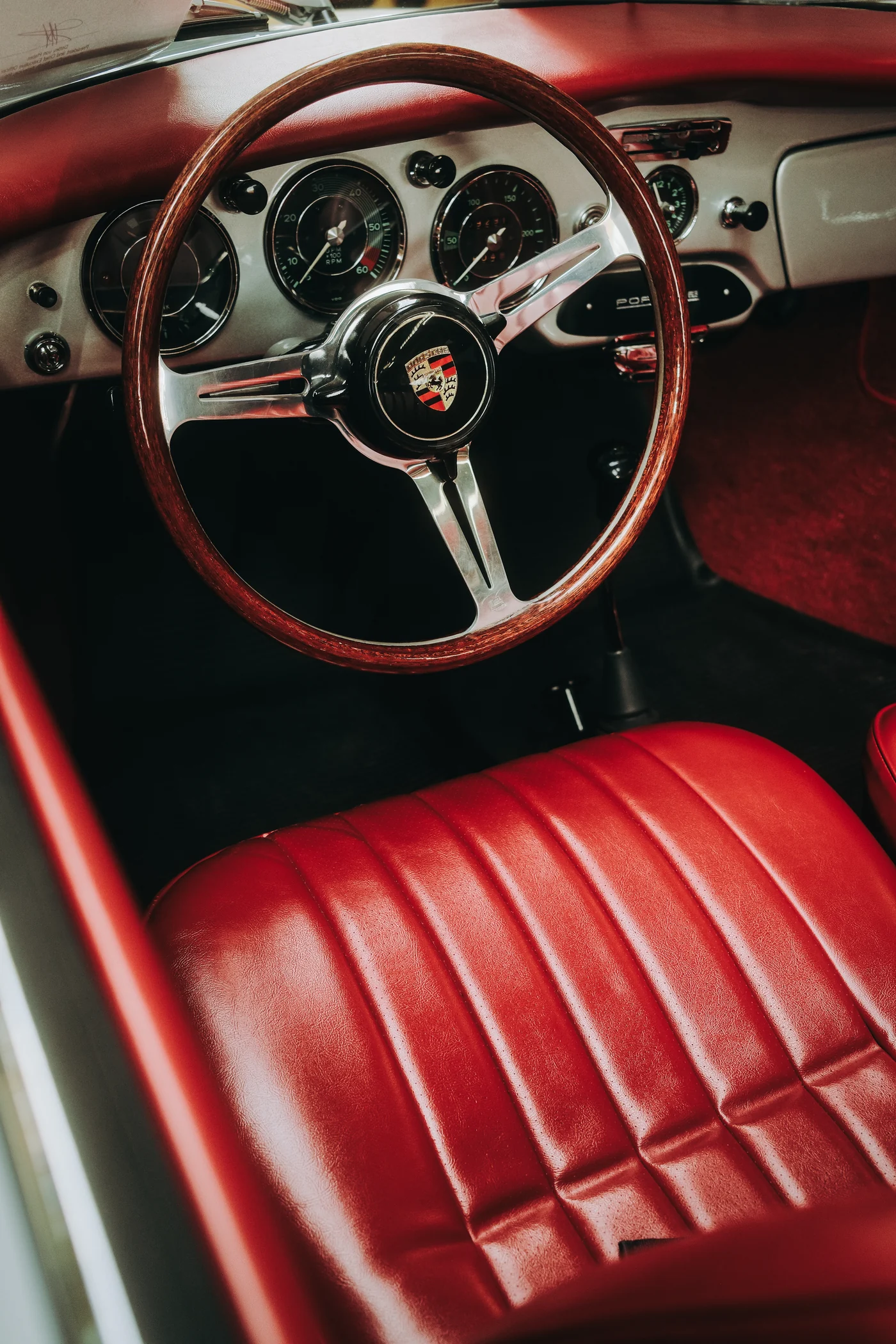 Ratt i trä och röda läderstolar i en klassisk Porsche