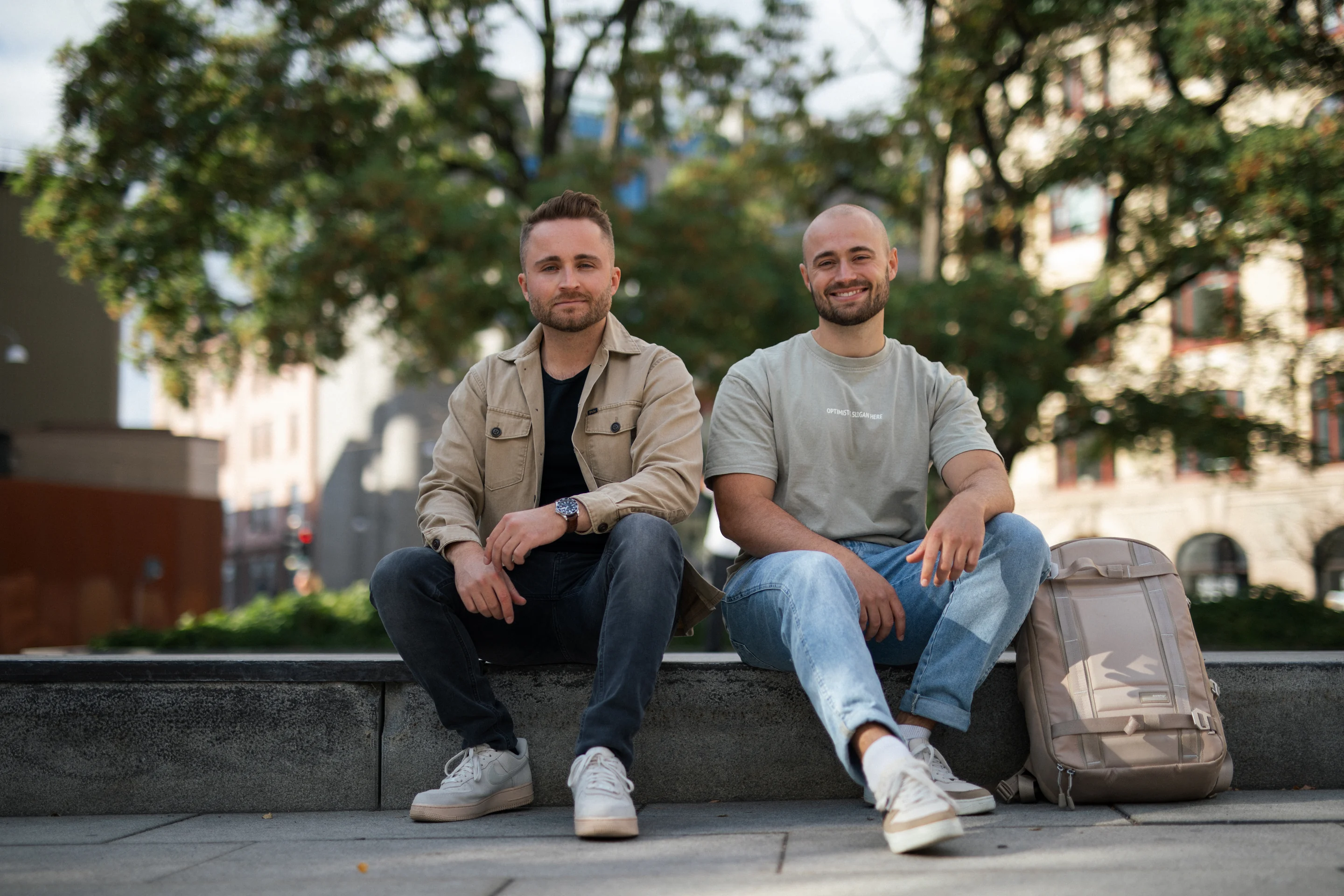 Nicklas och Filip Dahlgren sitter på en stenkant i en park